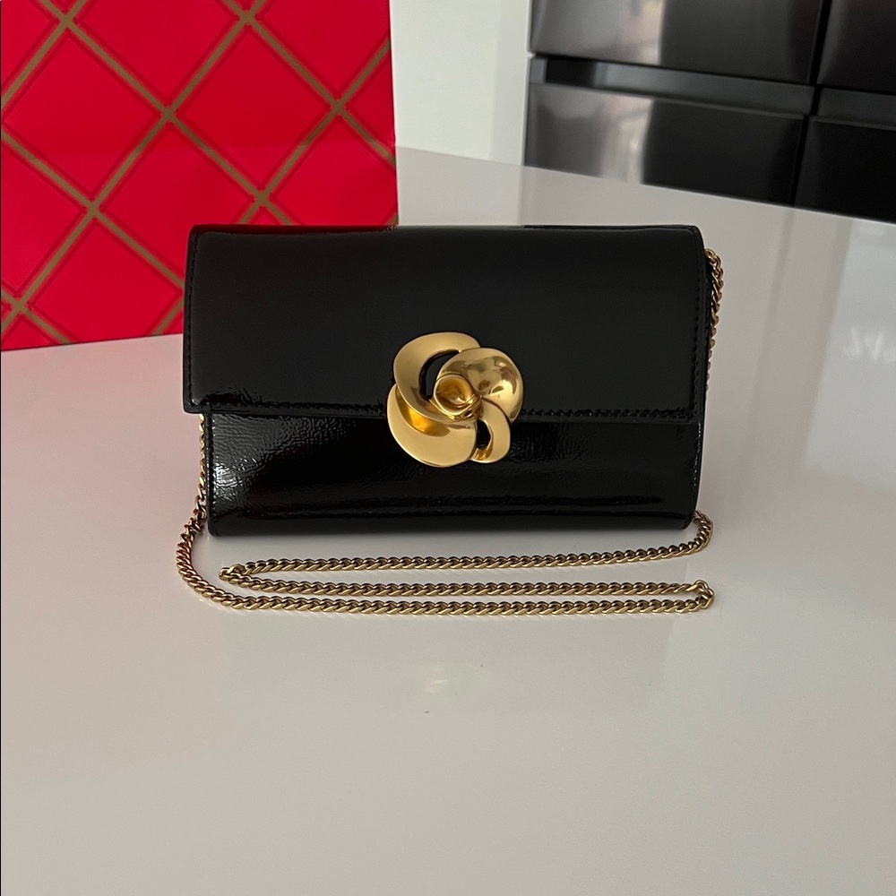 The Kira Rose Clutch, Black color with gold accents. NWT.